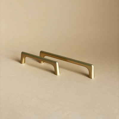 Dwa złote uchwyty meblowe Fibi o oryginalnym, nowoczesnym kształcie