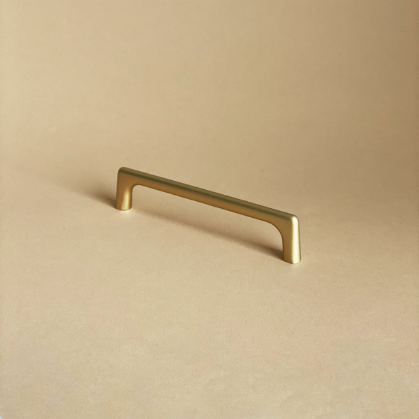 Złoty uchwyt meblowy Fibi to uchwyt o oryginalnym, nowoczesnym kształcie